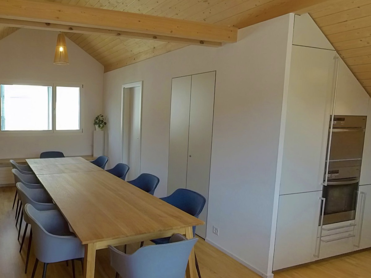 Dachgeschoss mit langem Holztisch und Küche